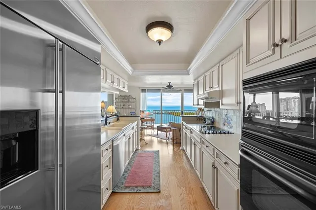 a kitchen with stainless steel appliances granite countertop a refrigerator a stove and a sink with cabinets