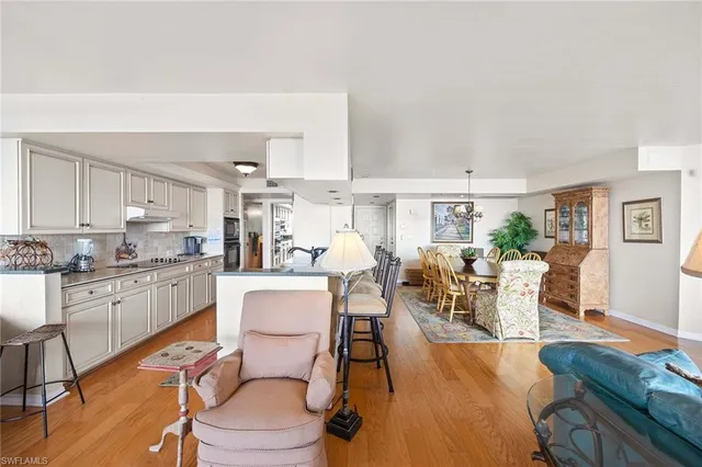 a kitchen with a table chairs stove and white cabinets