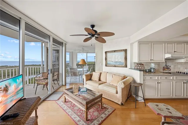 a living room with furniture a flat screen tv and a large window