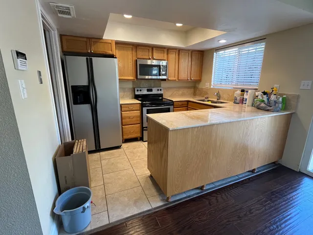 a kitchen with stainless steel appliances granite countertop a refrigerator a sink a stove a microwave a sink a refrigerator and cabinets