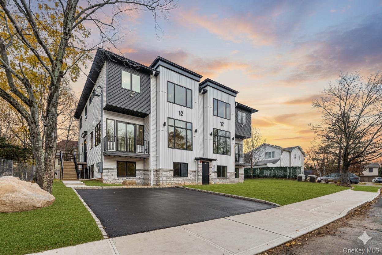 Modern home with stone siding, a front yard, board and batten siding, and stairs