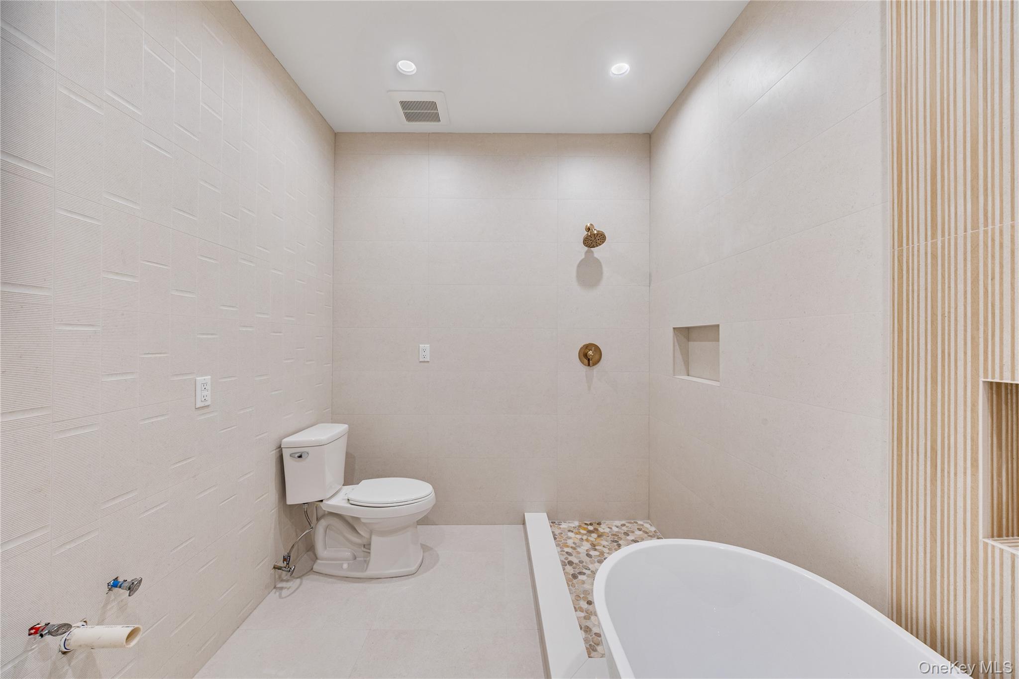 12 Buckman Place, Unit 101 Monsey, NY 10952 - Photo 27 of 50 Bathroom featuring tile walls, a freestanding bath, recessed lighting, tile patterned floors, and tiled shower