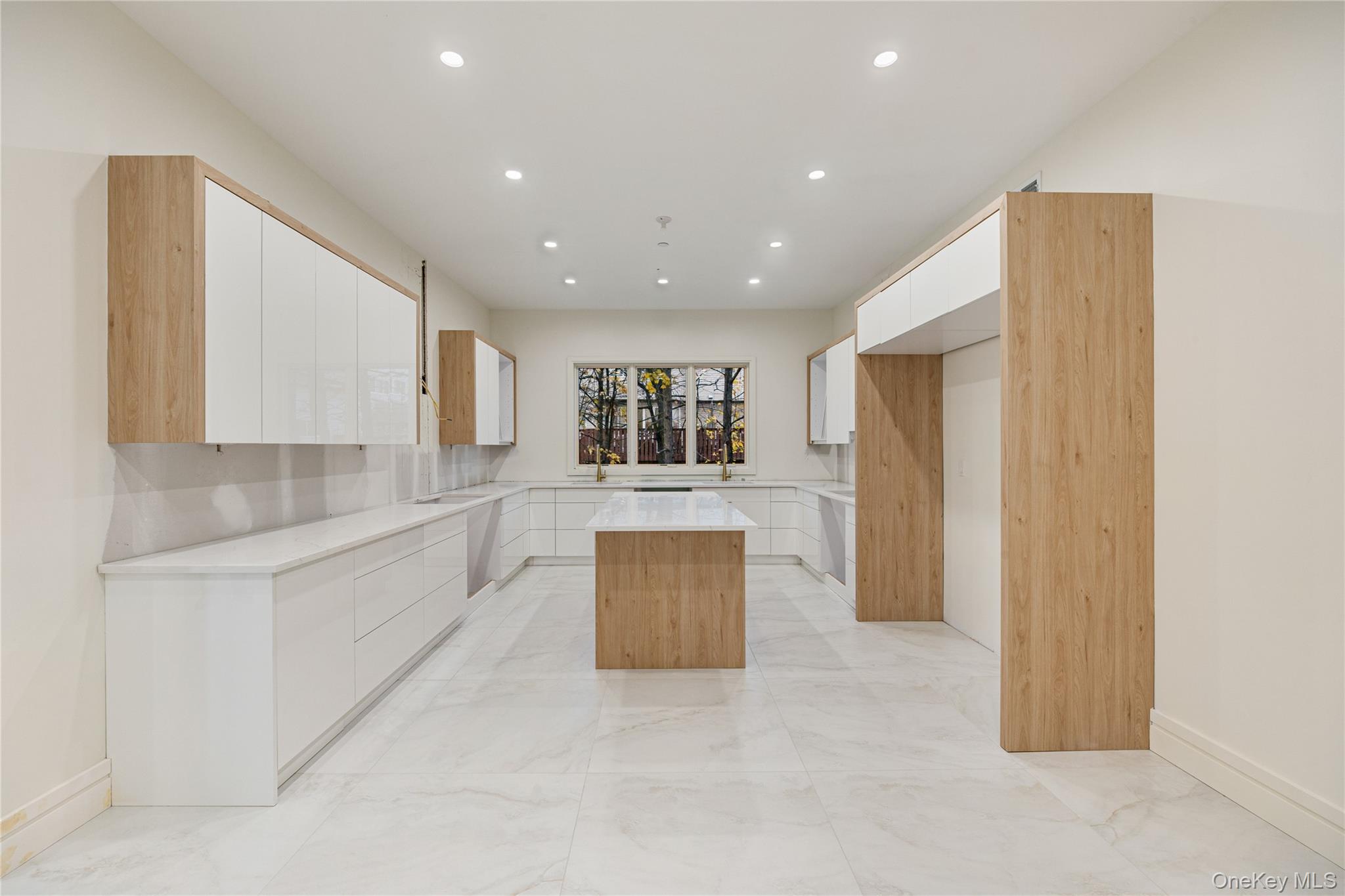 12 Buckman Place, Unit 101 Monsey, NY 10952 - Photo 10 of 50 Kitchen with modern cabinets, a kitchen island, light stone counters, white cabinetry, and recessed lighting