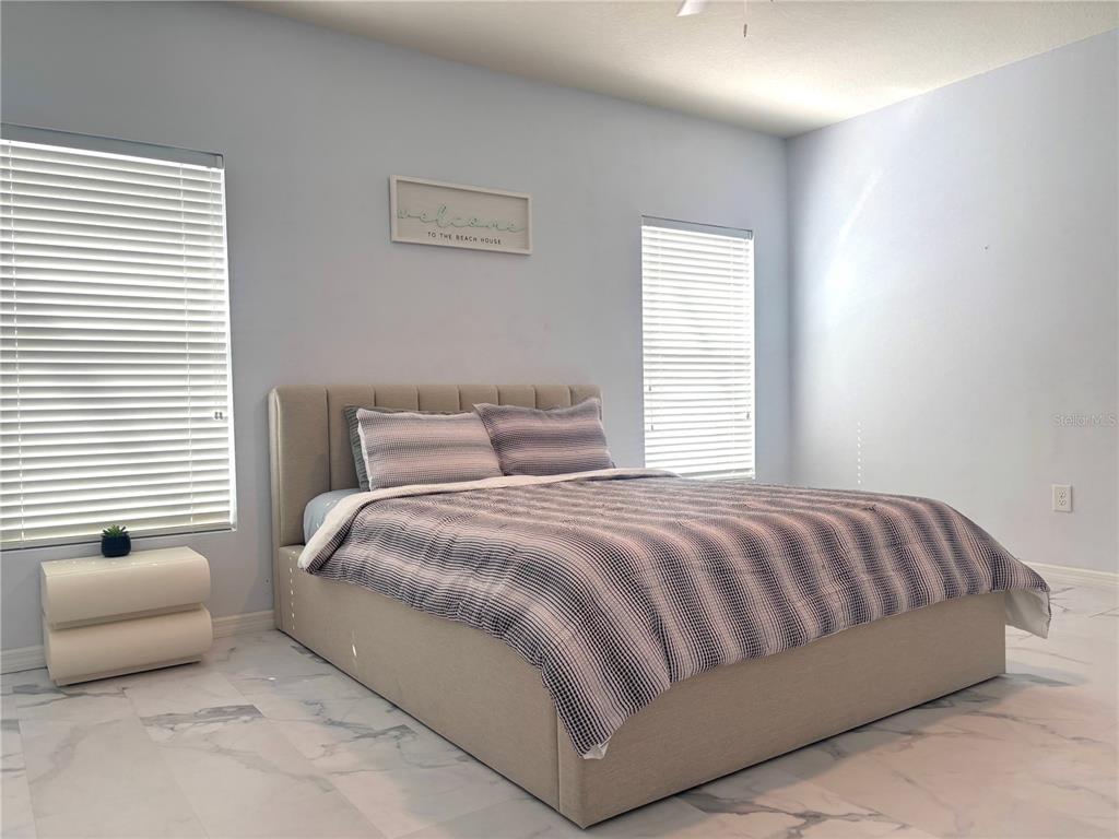 12107 Barnsley Reserve Place Gibsonton, FL 33534 - Photo 11 of 26 a bedroom with a bed and a couch