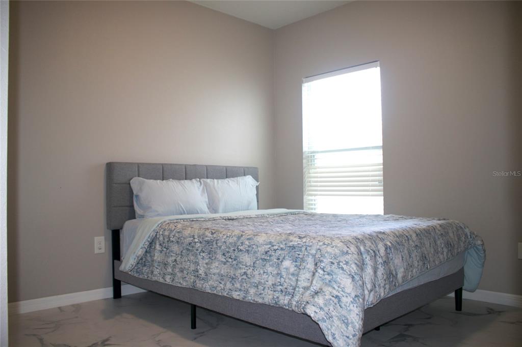 12107 Barnsley Reserve Place Gibsonton, FL 33534 - Photo 16 of 26 a bedroom with a bed and a night stand