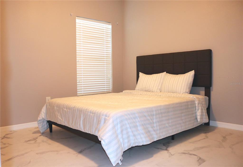 12107 Barnsley Reserve Place Gibsonton, FL 33534 - Photo 17 of 26 a bedroom with a bed and a night stand