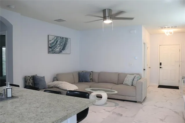 a living room with furniture and a ceiling fan