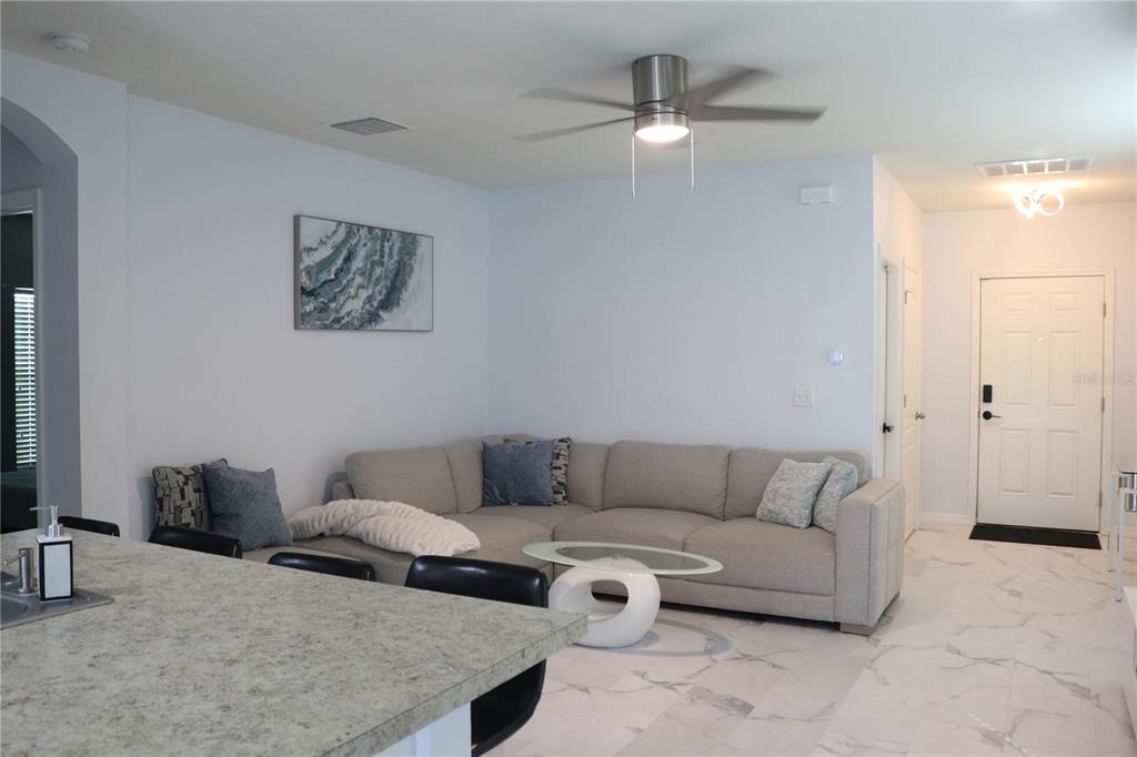 12107 Barnsley Reserve Place Gibsonton, FL 33534 - Photo 3 of 26 a living room with furniture and a ceiling fan