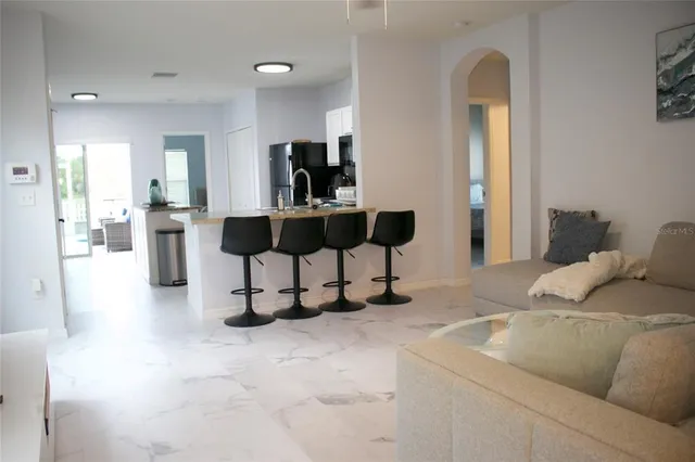 a living room with furniture and a dining table with kitchen island