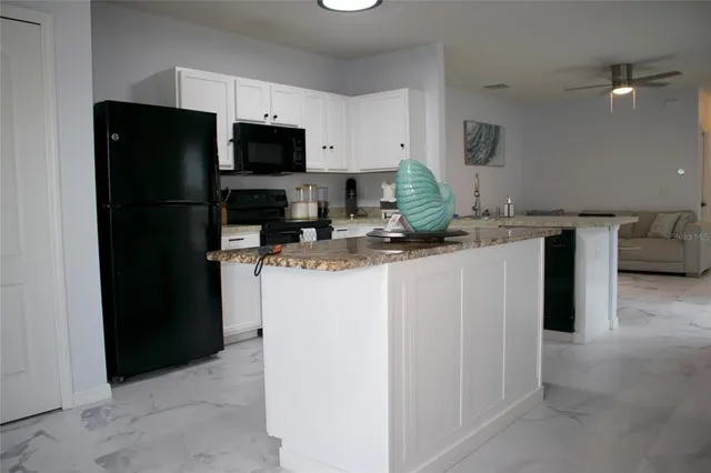 a kitchen with a sink a microwave a refrigerator and cabinets