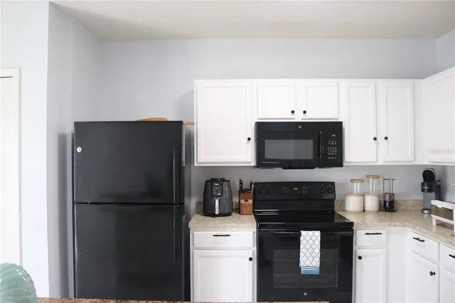 a kitchen with a refrigerator sink and cabinets
