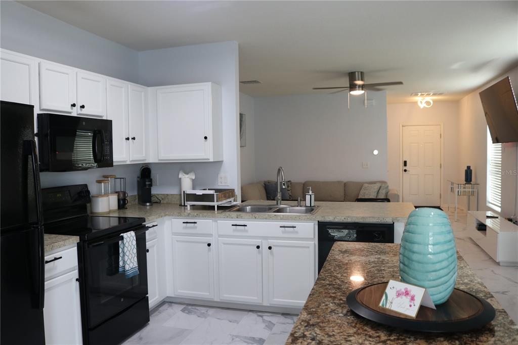 12107 Barnsley Reserve Place Gibsonton, FL 33534 - Photo 9 of 26 a kitchen with a sink appliances and cabinets