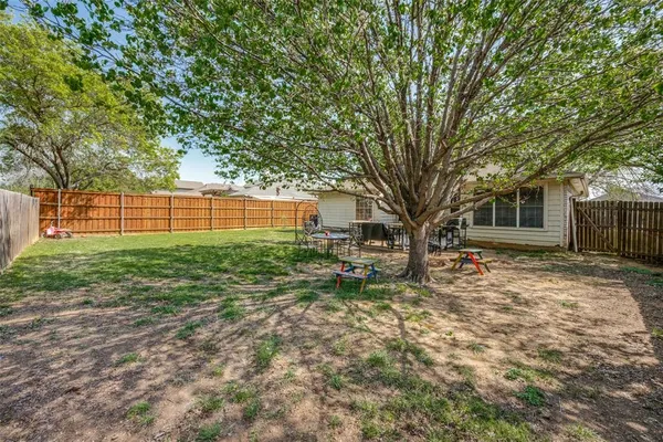 a view of a house with backyard and a tree