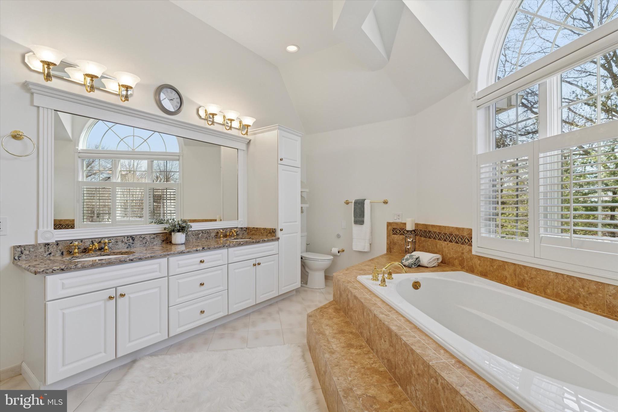 701 Brushtown Road Lower Gwynedd, PA 19002 - Photo 28 of 61 a bathroom with a tub double vanity sink and a large mirror