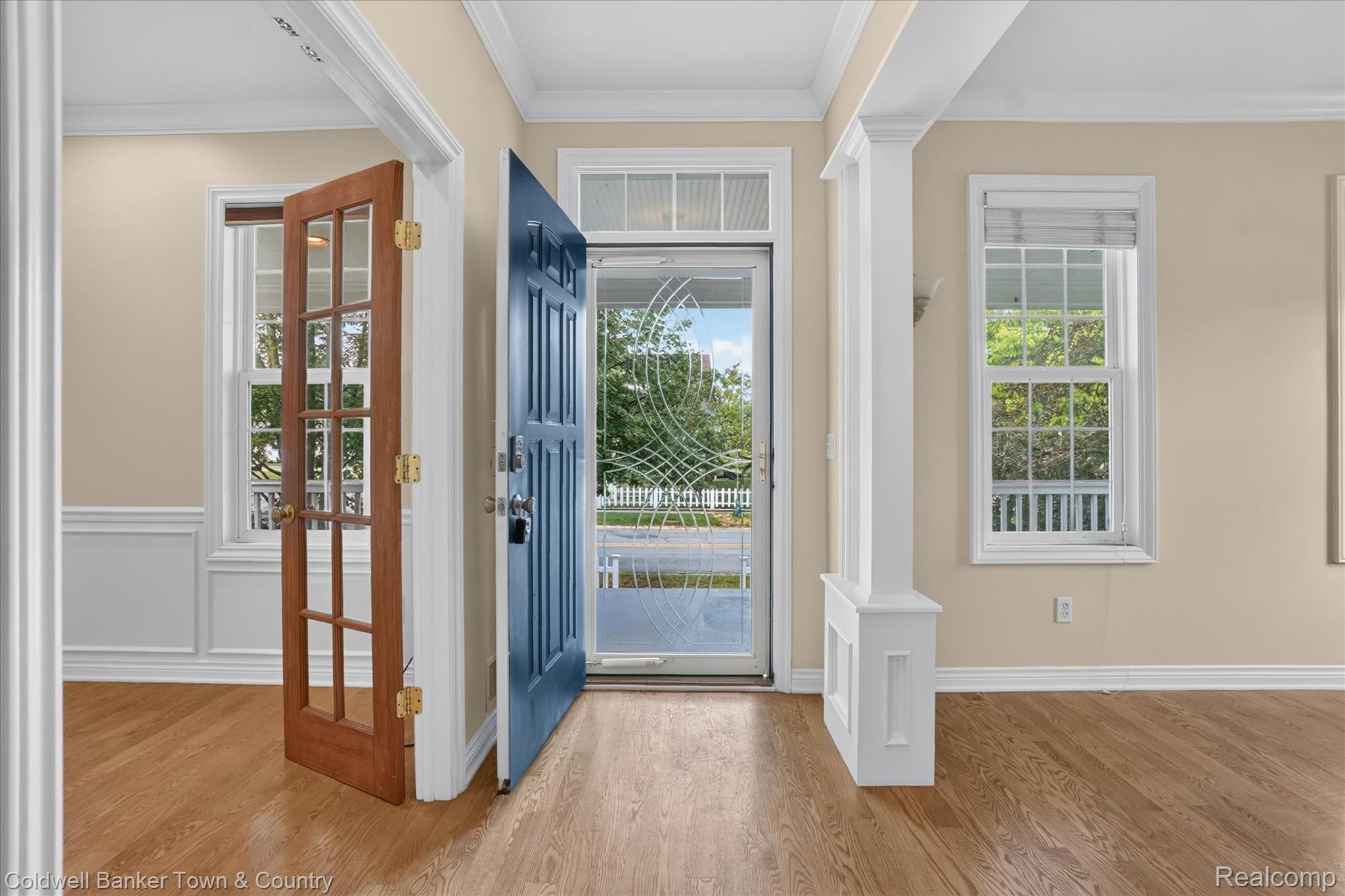 1725 Town Commons Drive Howell, MI 48855 - Photo 8 of 53 Entryway featuring wood-finish flooring, a blue front door with a transom window, and a glass storm door