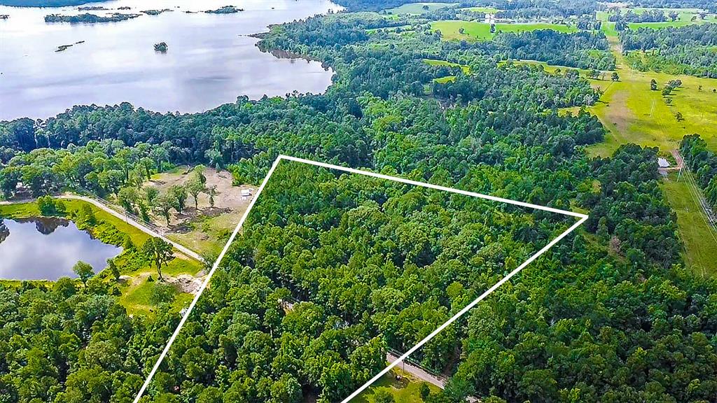 Aerial view of property and surrounding area with a nearby body of water and property boundaries highlighted