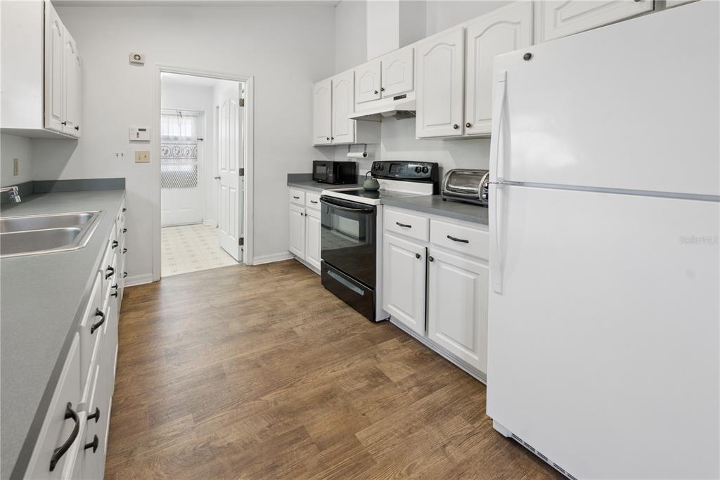 1750 Southwest 15th Street Bell, FL 32619 - Photo 10 of 34 a kitchen with white cabinets and white appliances