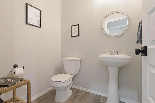 a bathroom with a toilet a sink and mirror
