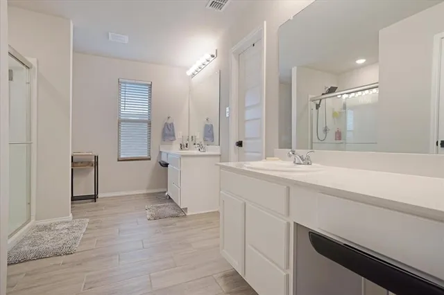 a bathroom with a sink a toilet a mirror and shower