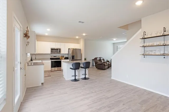 a view of a kitchen with kitchen island and stainless steel appliances