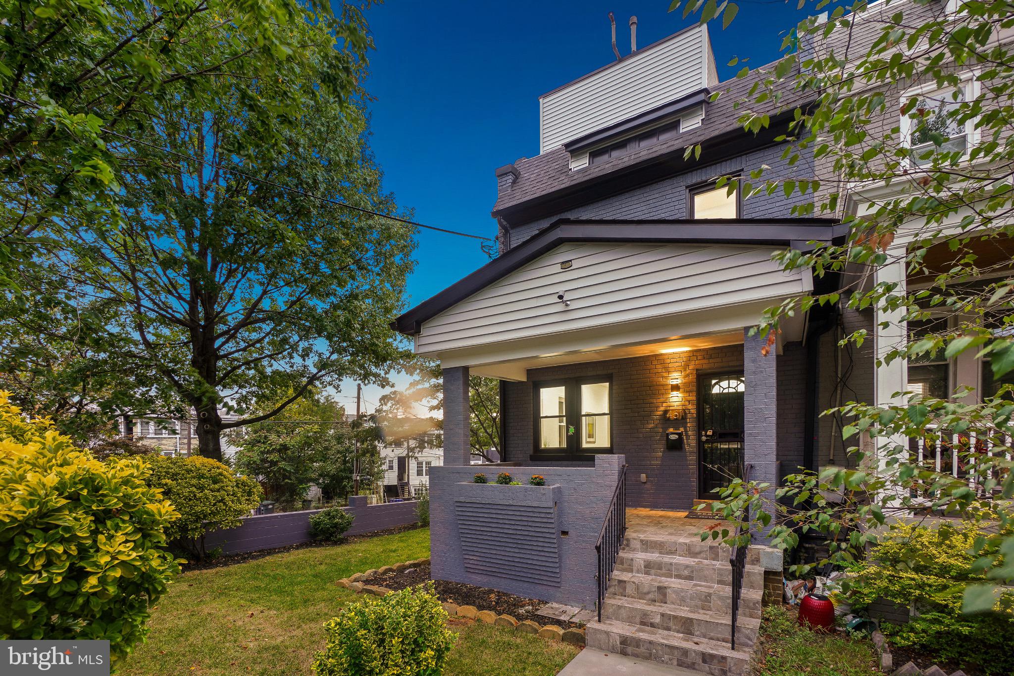 Charming home with lush greenery and inviting p...