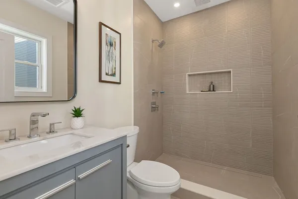 a bathroom with a granite countertop sink a toilet and shower