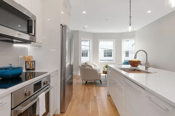 a living room with furniture a flat screen tv and windows
