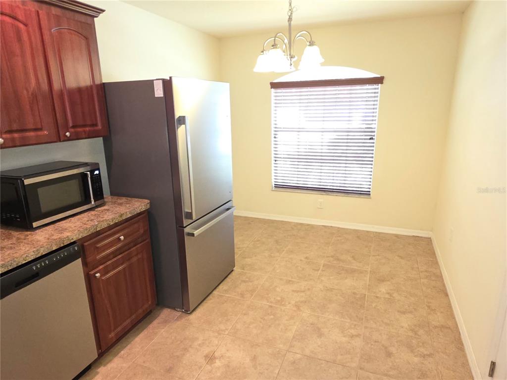 4284 High Ridge Avenue Spring Hill, FL 34609 - Photo 5 of 40 a kitchen with stainless steel appliances granite countertop a refrigerator a stove and a wooden cabinets