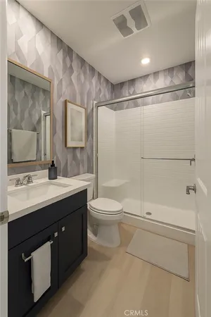 a bathroom with a sink a toilet and shower