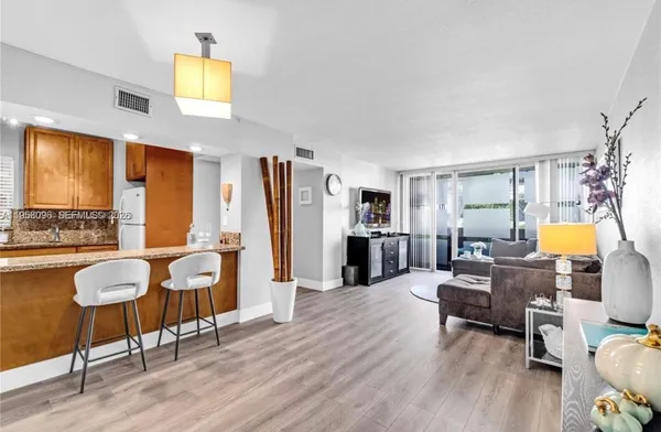 a living room with furniture and a kitchen view