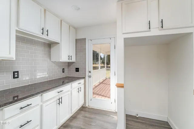 a kitchen with granite countertop white cabinets and white appliances