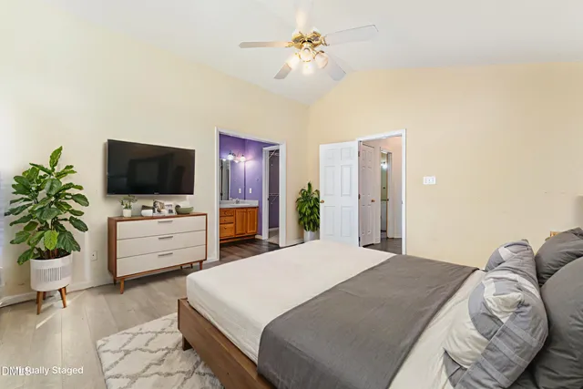 a bedroom with a bed flat screen tv and a potted plant