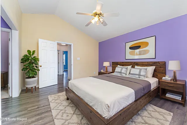 a spacious bedroom with a bed and a potted plant