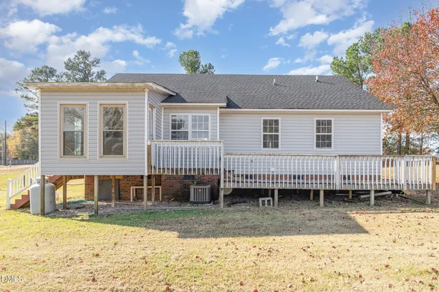 a view of a house with a yard and wooden fence