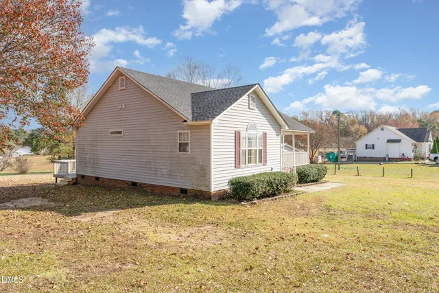 a view of a house with backyard and trees