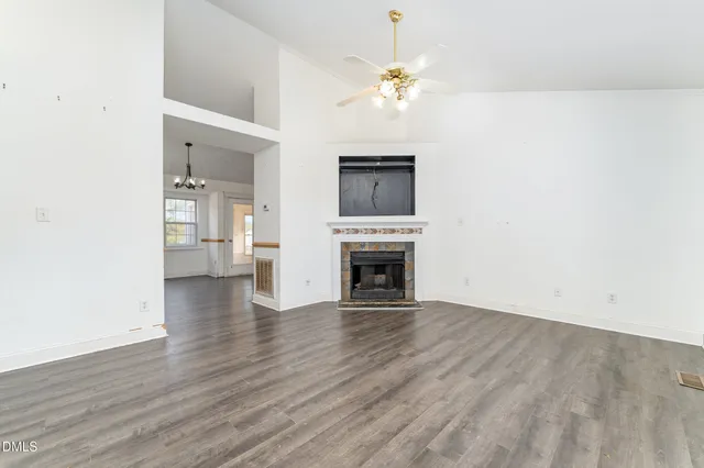 an empty room with wooden floor and fireplace