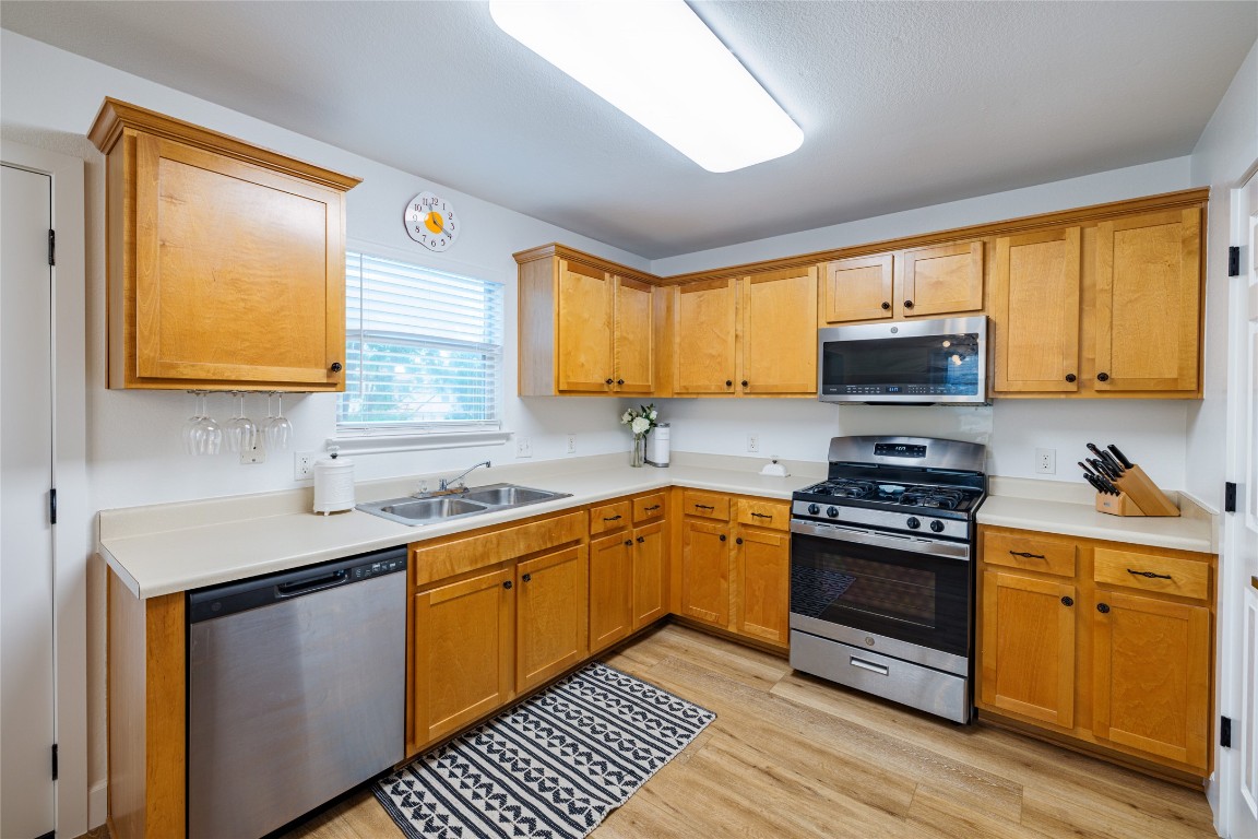 1130 Sundrop Place Round Rock, TX 78665 - Photo 7 of 18 a kitchen with stainless steel appliances granite countertop wooden cabinets a stove a sink and a window