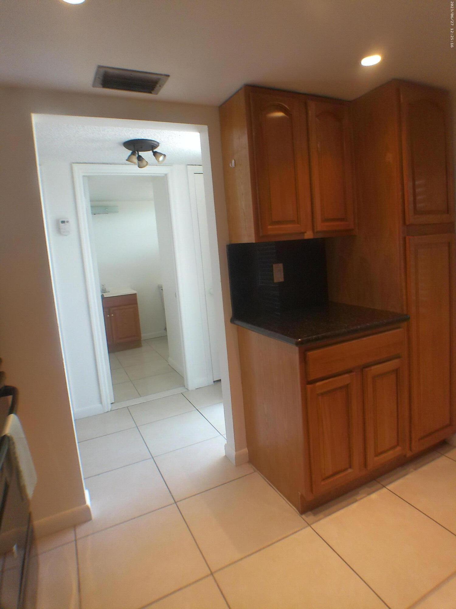 9872 Marina Boulevard, Unit 1434 Boca Raton, FL 33428 - Photo 13 of 63 a kitchen with granite countertop a refrigerator and cabinets