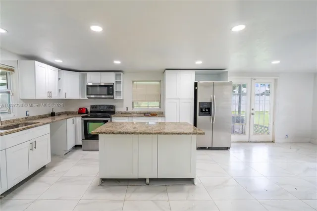 a kitchen with a refrigerator and a stove top oven