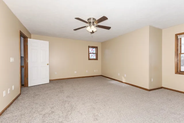 an empty room with closet and a ceiling fan