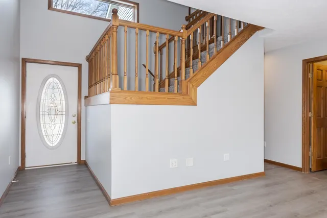 a view of a hallway with entryway wooden floor and front door