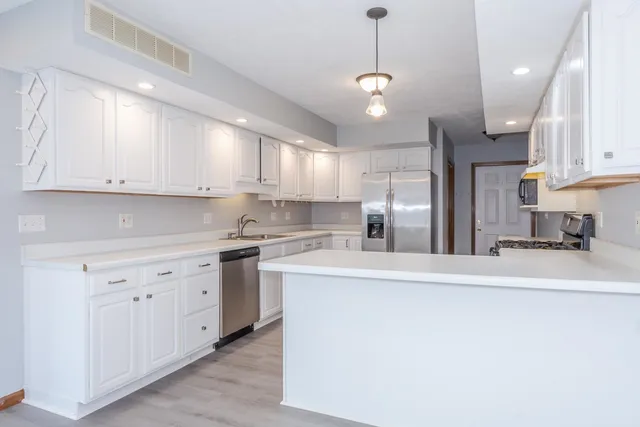 a kitchen with stainless steel appliances granite countertop a sink a stove and a refrigerator