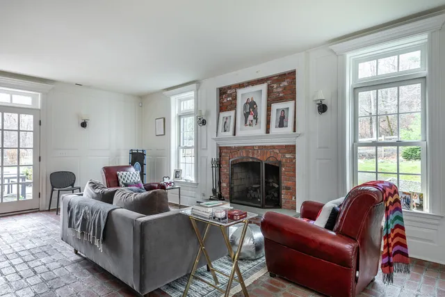 a living room with furniture a large window and a fireplace