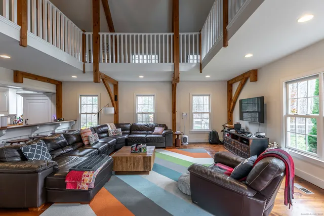 a living room with furniture fireplace and a window