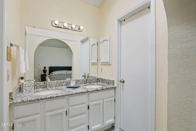 a bathroom with a granite countertop sink a toilet a mirror and shower