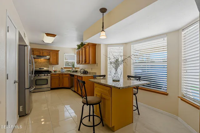 a kitchen with stainless steel appliances granite countertop a refrigerator stove and sink