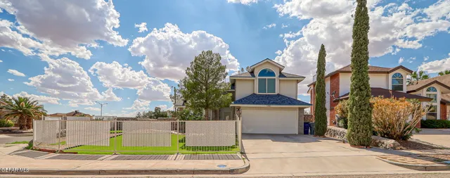 a view of a white house with a yard and plants