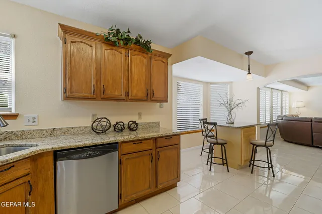 a kitchen with granite countertop stainless steel appliances a stove sink and cabinets