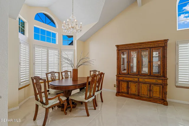 a dining room with furniture a chandelier and window