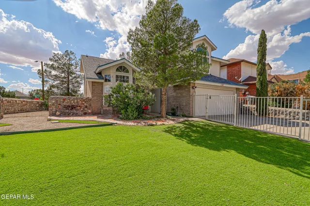 a front view of small house with yard and green space